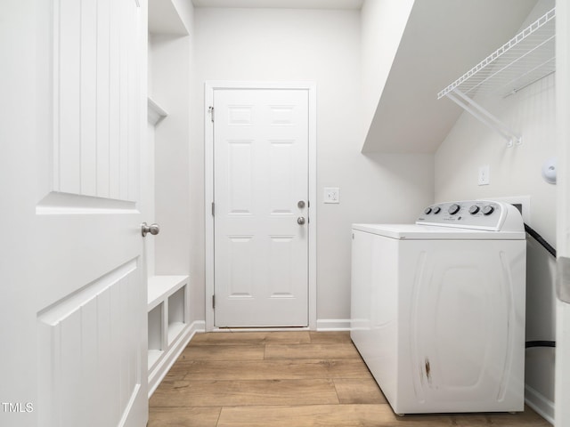 washroom featuring washer / clothes dryer, laundry area, and light wood-type flooring
