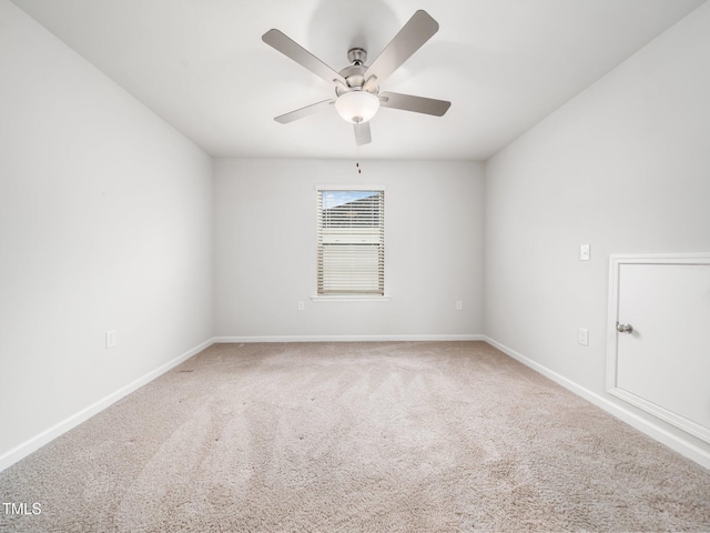 carpeted empty room with baseboards and a ceiling fan