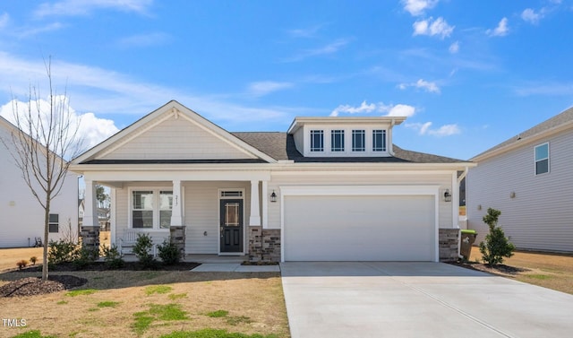 craftsman house with stone siding, concrete driveway, and covered porch