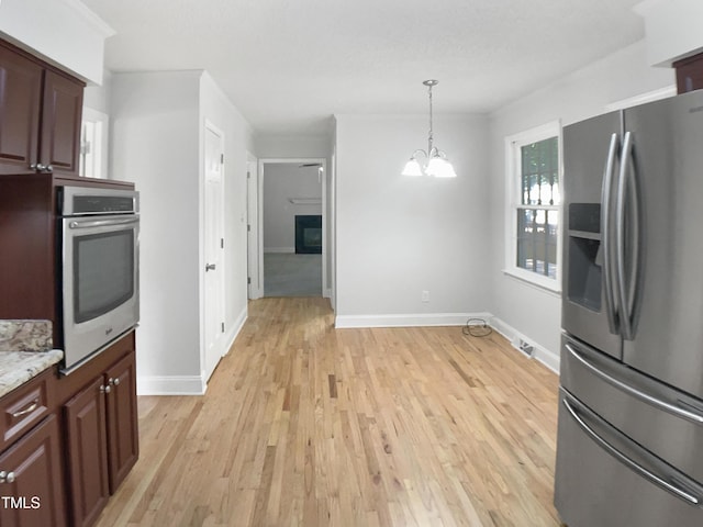 4601 Pemberton Dr, Raleigh, NC 27609 - kitchen with appliances with stainless steel finishes, a chandelier, light wood-style flooring, decorative light fixtures, and light stone counters