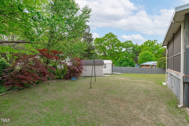 view of yard featuring a storage shed, an outbuilding, and a fenced backyard