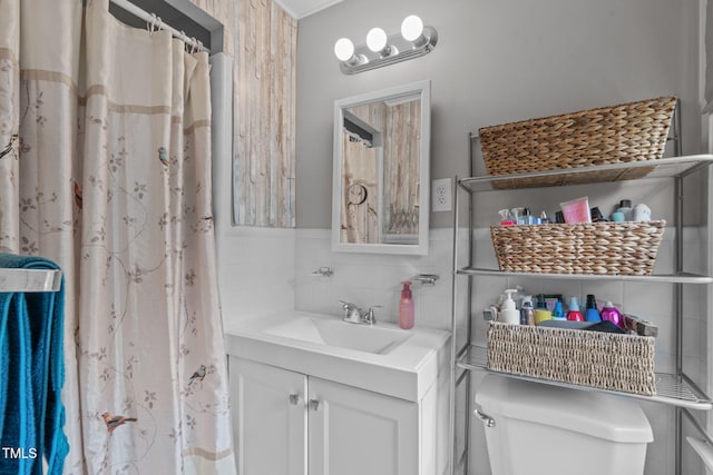 bathroom featuring toilet, tile walls, curtained shower, and vanity