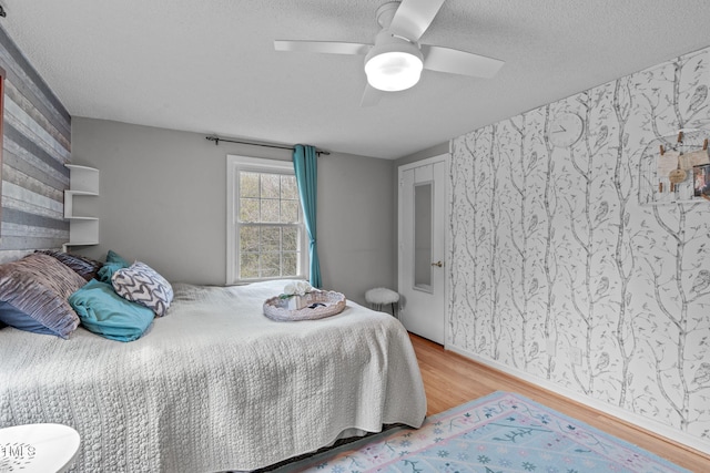 bedroom featuring a ceiling fan, a textured ceiling, and wood finished floors