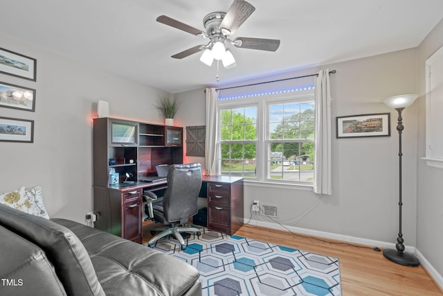 office area featuring baseboards, a ceiling fan, wood finished floors, and visible vents