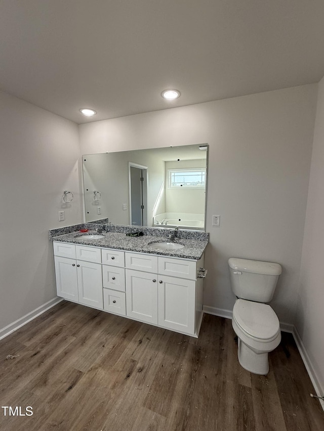 full bath with wood finished floors, baseboards, and a sink