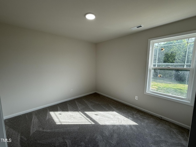 unfurnished room featuring baseboards, visible vents, and carpet