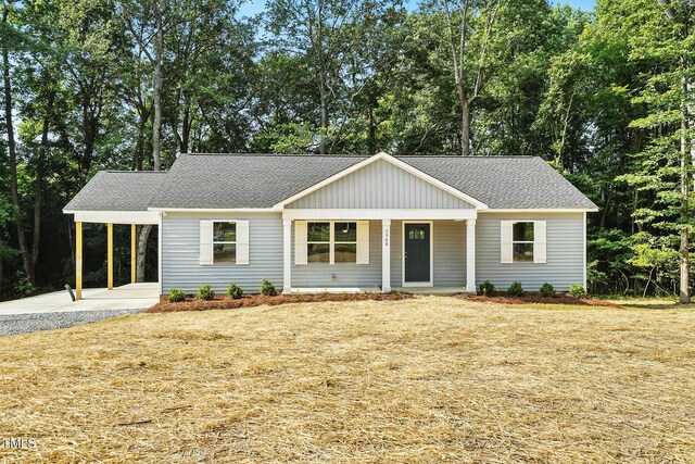 5500 Lake Wendell Rd, Zebulon, NC 27597 - ranch-style home with a carport, driveway, a shingled roof, a porch, and view of scattered trees