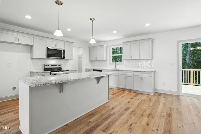 5500 Lake Wendell Rd, Zebulon, NC 27597 - kitchen featuring stainless steel appliances, backsplash, light wood-type flooring, a kitchen breakfast bar, and recessed lighting