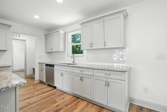 5500 Lake Wendell Rd, Zebulon, NC 27597 - kitchen with stainless steel dishwasher, decorative backsplash, light wood-style flooring, recessed lighting, and light stone counters