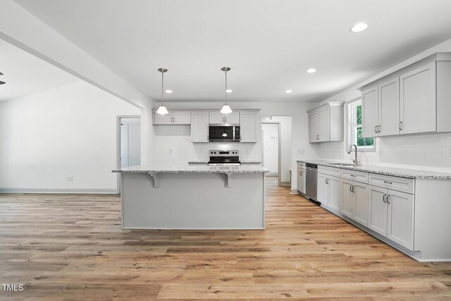 5500 Lake Wendell Rd, Zebulon, NC 27597 - kitchen featuring stainless steel appliances, backsplash, recessed lighting, light wood-type flooring, and light stone counters
