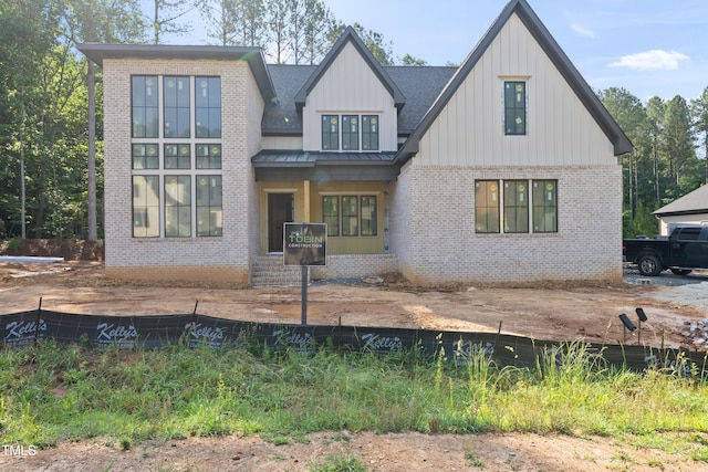 2957 Wexford Pond Way, Wake Forest, NC 27587 - view of front of house featuring brick siding, a standing seam roof, board and batten siding, metal roof, and a shingled roof
