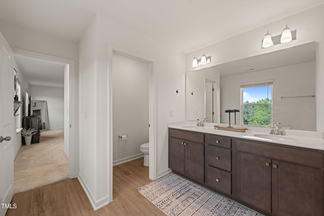 1417 Underbrush Dr, Durham, NC 27703 - bathroom featuring double vanity, wood finished floors, toilet, and a sink