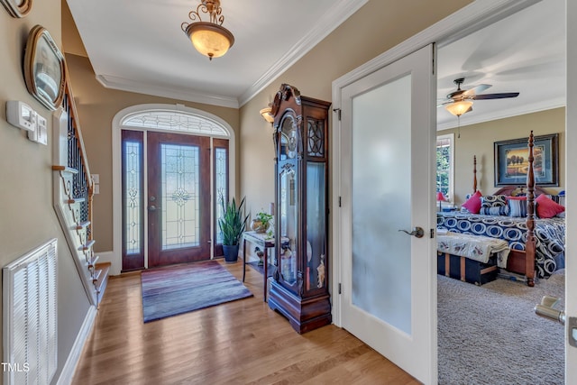 5595 Godwin Lake Rd, Benson, NC 27504 - entrance foyer with visible vents, crown molding, wood finished floors, baseboards, and a ceiling fan