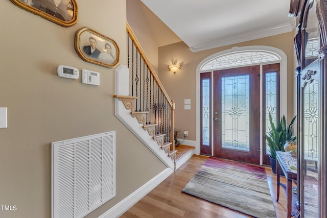 5595 Godwin Lake Rd, Benson, NC 27504 - entrance foyer featuring visible vents, crown molding, wood finished floors, baseboards, and stairway