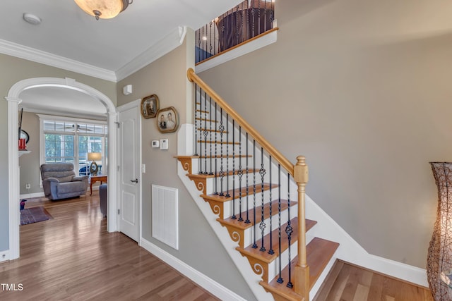 5595 Godwin Lake Rd, Benson, NC 27504 - stairway featuring crown molding, arched walkways, baseboards, wood finished floors, and visible vents