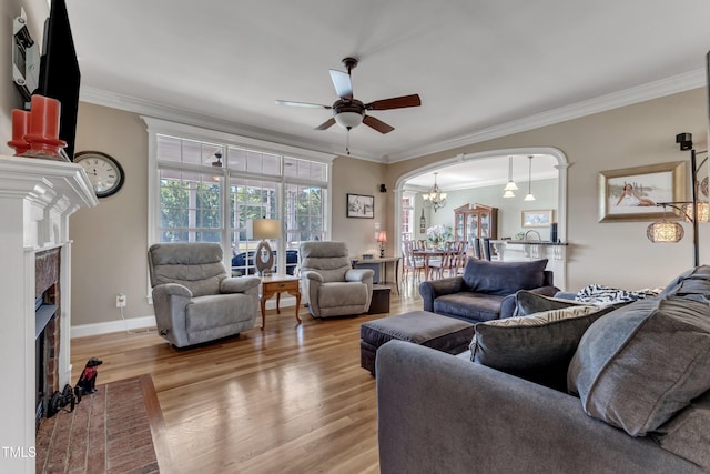 5595 Godwin Lake Rd, Benson, NC 27504 - living area with crown molding, light wood-style floors, a fireplace, and ceiling fan with notable chandelier