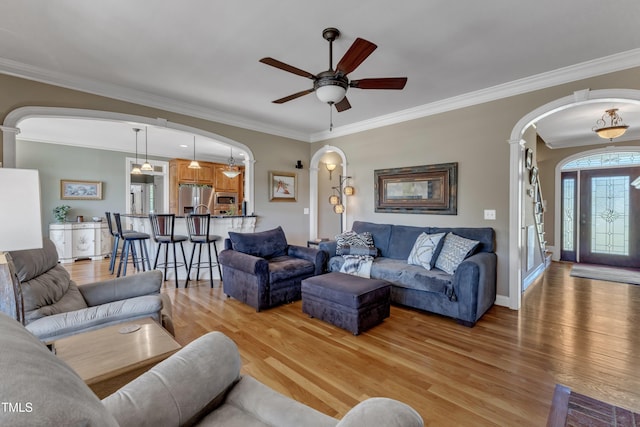 5595 Godwin Lake Rd, Benson, NC 27504 - living room with crown molding, light wood finished floors, arched walkways, a ceiling fan, and baseboards
