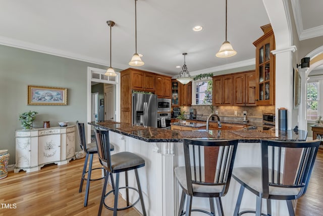 5595 Godwin Lake Rd, Benson, NC 27504 - kitchen featuring brown cabinetry, decorative backsplash, plenty of natural light, and stainless steel appliances