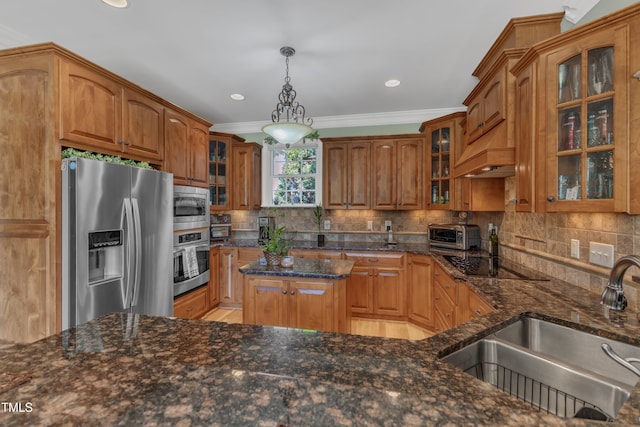 5595 Godwin Lake Rd, Benson, NC 27504 - kitchen with dark stone counters, brown cabinets, a sink, appliances with stainless steel finishes, and backsplash