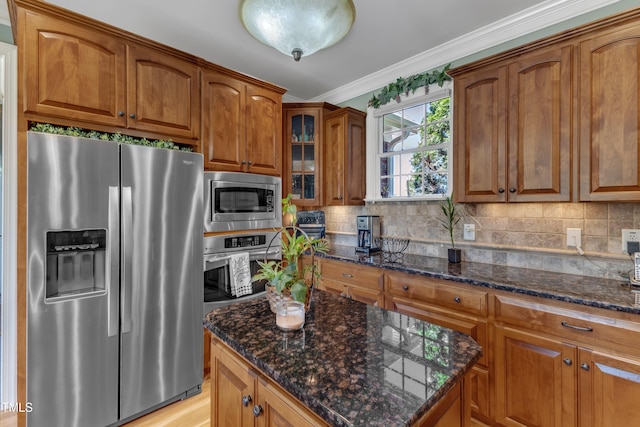 5595 Godwin Lake Rd, Benson, NC 27504 - kitchen with crown molding, dark stone counters, brown cabinetry, and stainless steel appliances