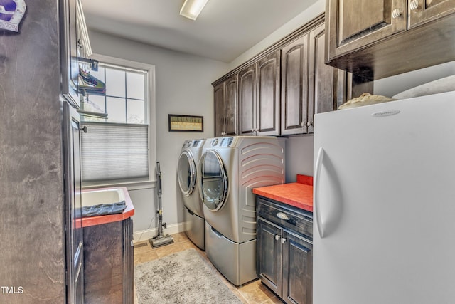 5595 Godwin Lake Rd, Benson, NC 27504 - clothes washing area featuring cabinet space, independent washer and dryer, baseboards, and light tile patterned floors