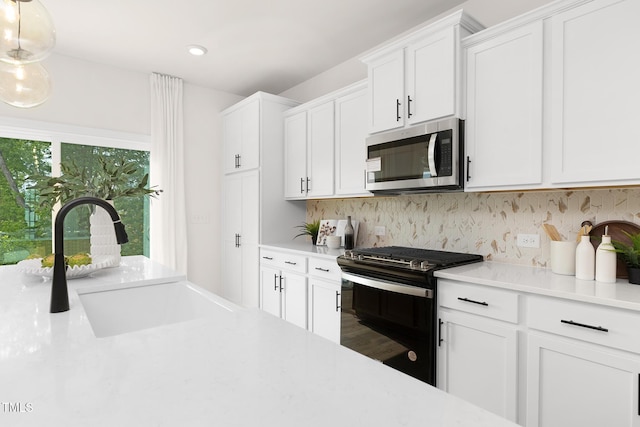 111 Silver Moon Ln Unit 121, Clayton, NC 27527 - kitchen with black gas stove, stainless steel microwave, light countertops, and a sink