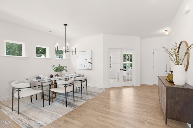 111 Silver Moon Ln Unit 121, Clayton, NC 27527 - dining area featuring a notable chandelier, french doors, wood finished floors, and baseboards