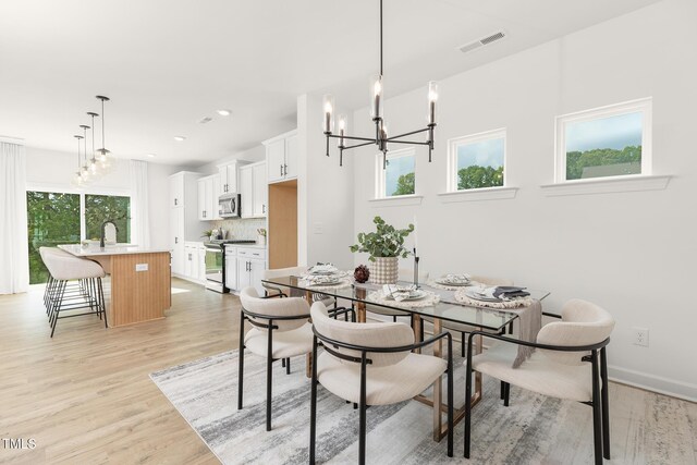 111 Silver Moon Ln Unit 121, Clayton, NC 27527 - dining room featuring light wood-style flooring, visible vents, baseboards, recessed lighting, and a notable chandelier