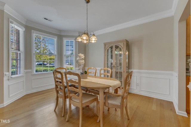 9005 River Estates Dr, Knightdale, NC 27545 - dining space featuring visible vents, wainscoting, a notable chandelier, ornamental molding, and light wood-style flooring