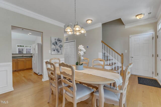 9005 River Estates Dr, Knightdale, NC 27545 - dining space featuring crown molding, an inviting chandelier, and light wood-style floors