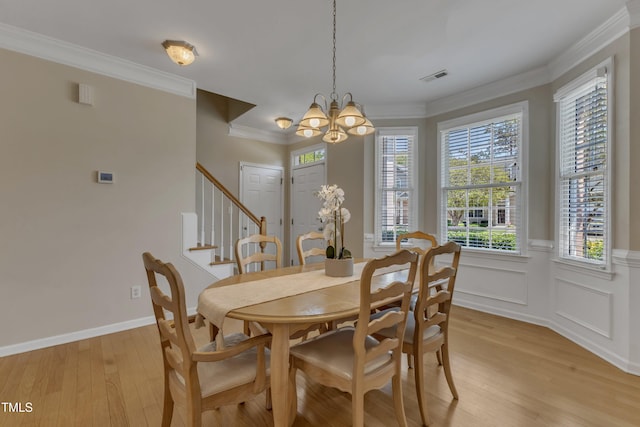 9005 River Estates Dr, Knightdale, NC 27545 - dining space with crown molding, light wood finished floors, a chandelier, visible vents, and stairway