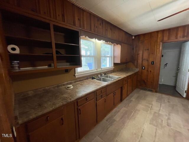 906 Camden Ave, Durham, NC 27701 - kitchen with wooden walls, brown cabinetry, and light countertops