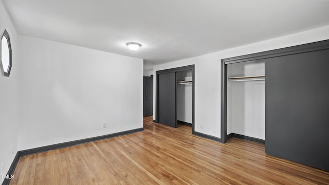 114 Barnhill St, Durham, NC 27707 - unfurnished bedroom featuring two closets and light wood finished floors