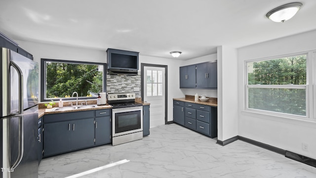 114 Barnhill St, Durham, NC 27707 - kitchen featuring appliances with stainless steel finishes, light marble finish flooring, ventilation hood, tasteful backsplash, and healthy amount of natural light