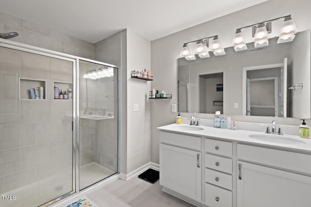 bathroom with tile patterned floors, double vanity, a sink, and a stall shower