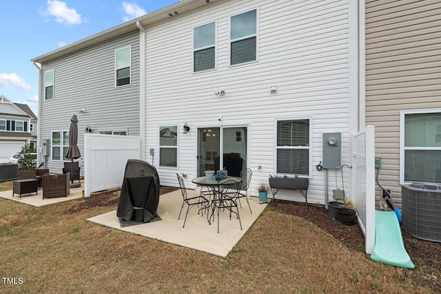 rear view of property featuring a patio, cooling unit, fence, and a lawn