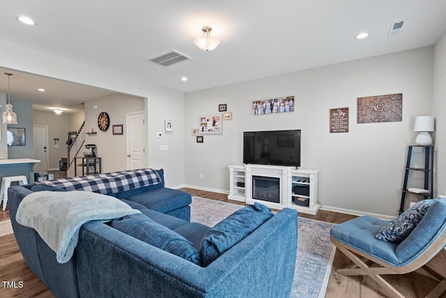 living area with dark wood-style flooring, visible vents, and recessed lighting