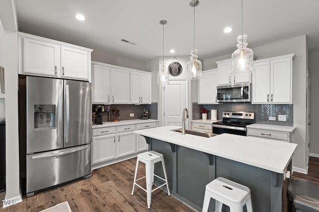 kitchen with dark wood-type flooring, visible vents, white cabinets, and stainless steel appliances