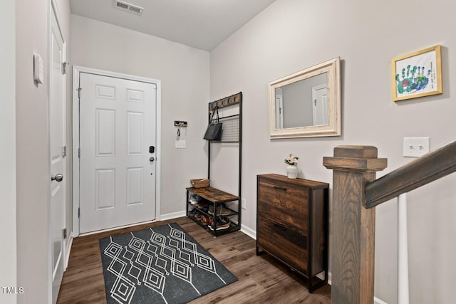foyer featuring visible vents, baseboards, and dark wood-style floors