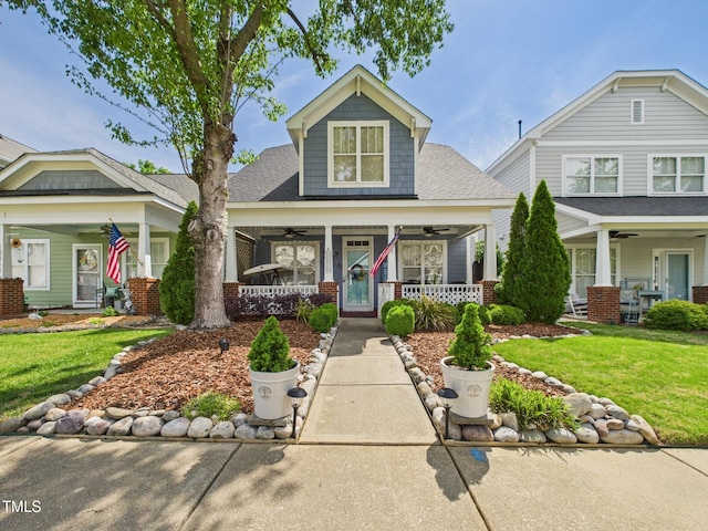 view of front of home featuring a ceiling fan, a front lawn, and covered porch