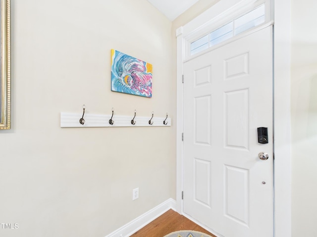 doorway with wood finished floors and baseboards