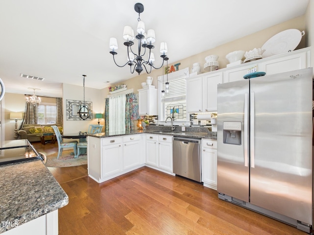 kitchen with a peninsula, visible vents, a chandelier, and appliances with stainless steel finishes