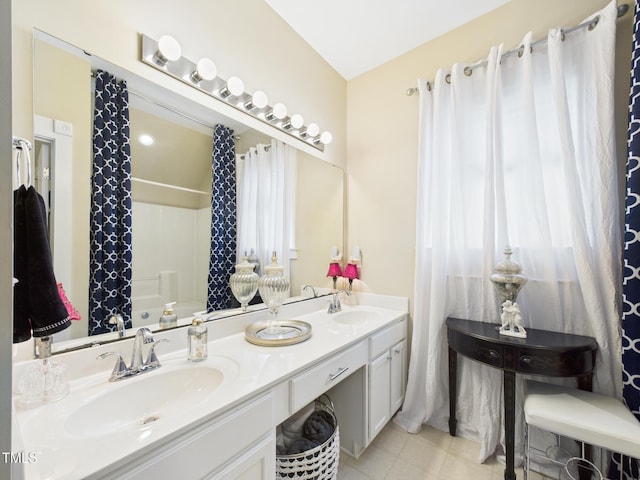 full bath with a shower with shower curtain, double vanity, tile patterned floors, and a sink
