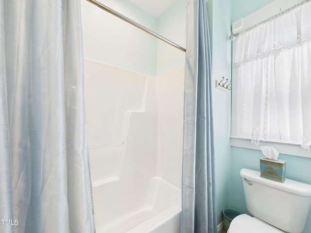 bathroom featuring shower / bath combo and toilet
