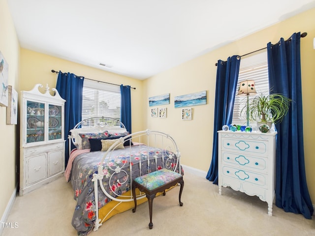 carpeted bedroom featuring baseboards and visible vents