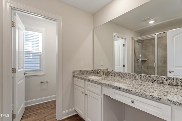 bathroom featuring visible vents, a shower stall, baseboards, wood finished floors, and vanity