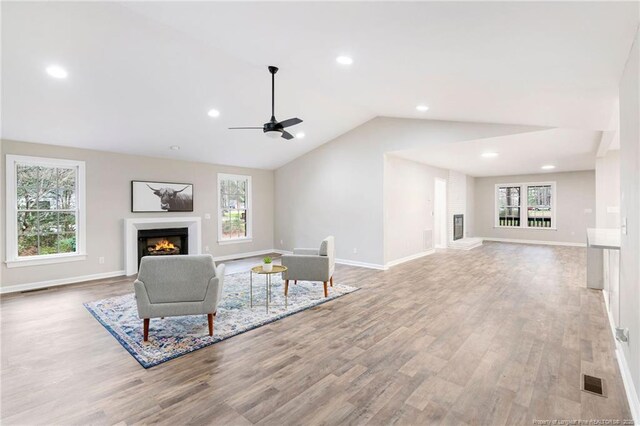 1429 Pocosin Rd, Winterville, NC 28590 - unfurnished living room featuring a warm lit fireplace, lofted ceiling, visible vents, and wood finished floors
