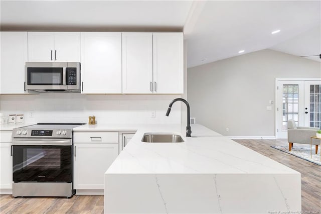 1429 Pocosin Rd, Winterville, NC 28590 - kitchen featuring a sink, light wood finished floors, white cabinetry, light stone countertops, and appliances with stainless steel finishes