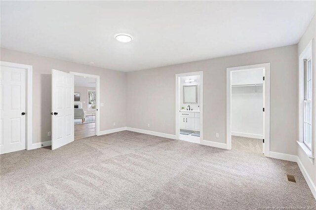 1429 Pocosin Rd, Winterville, NC 28590 - unfurnished bedroom featuring connected bathroom, carpet floors, a sink, a spacious closet, and baseboards