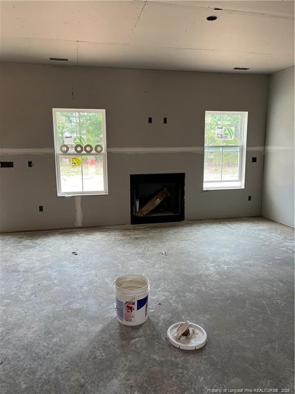 228 Dove Rd, Cameron, NC 28326 - unfurnished living room featuring plenty of natural light, a fireplace, and concrete floors